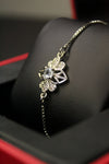 Delicate silver bracelet with floral design on a black surface