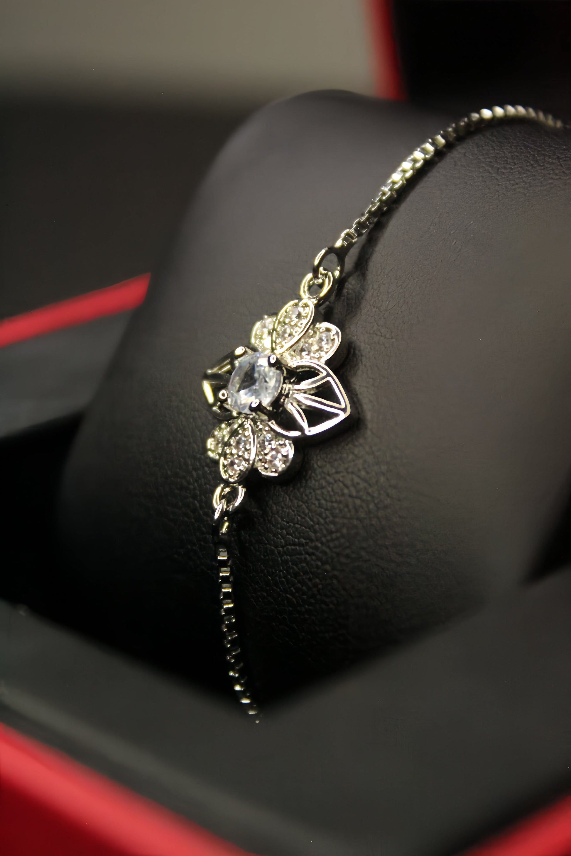 Delicate silver bracelet with floral design on a black surface